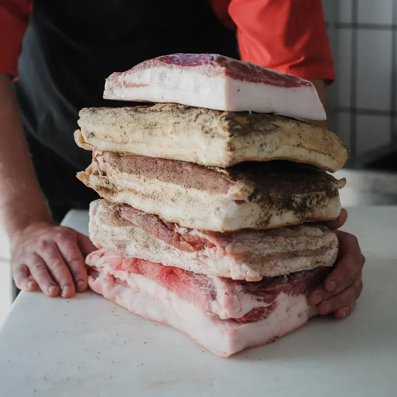 Lardo e guanciale stagionati impilati sul banco